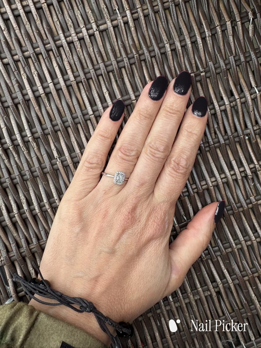 The same hand again, nails in a deep near-black with a faint plum cast.