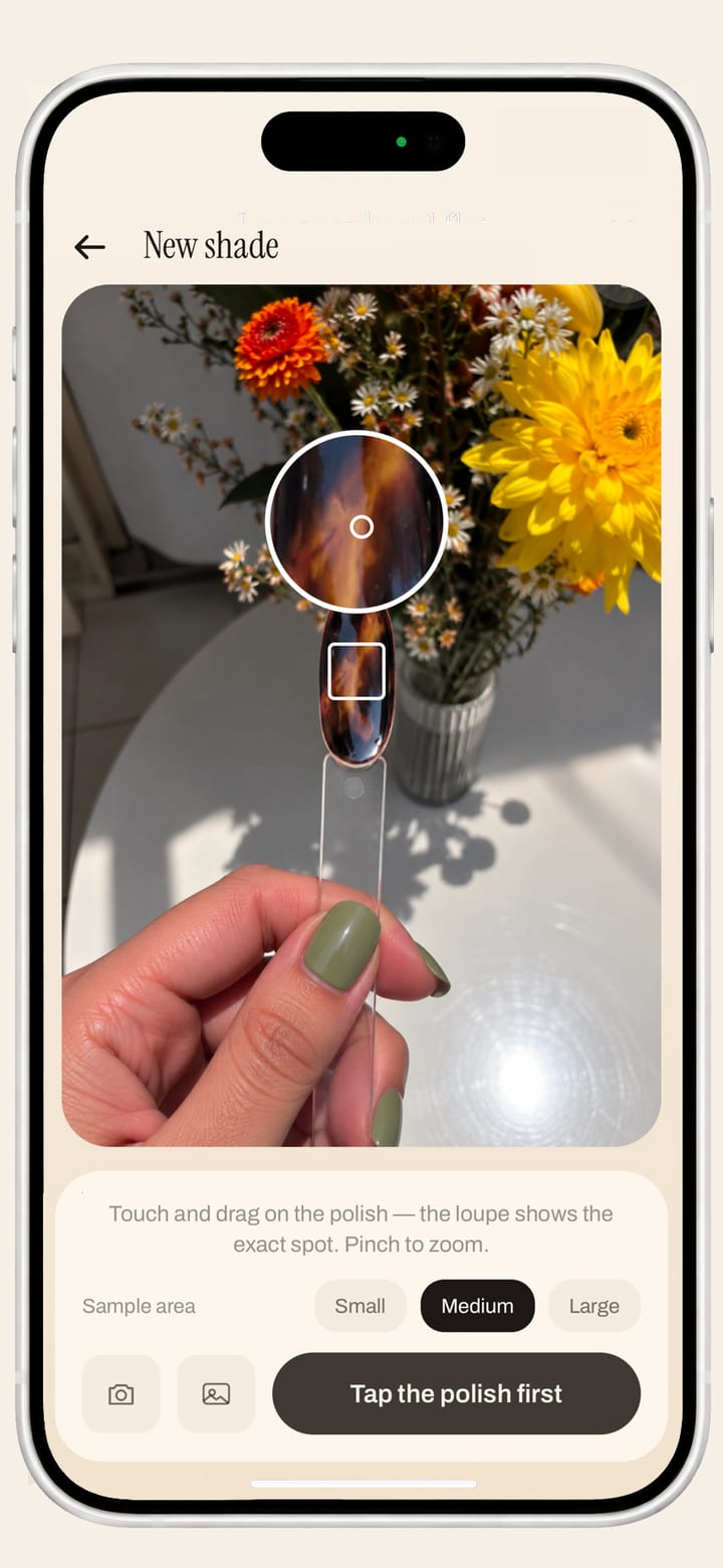 The new-shade screen: a tiger-eye swatch tip held up against a bunch of flowers, with a magnifying loupe over it and a sample-size control below, picking the exact colour out of the photo.